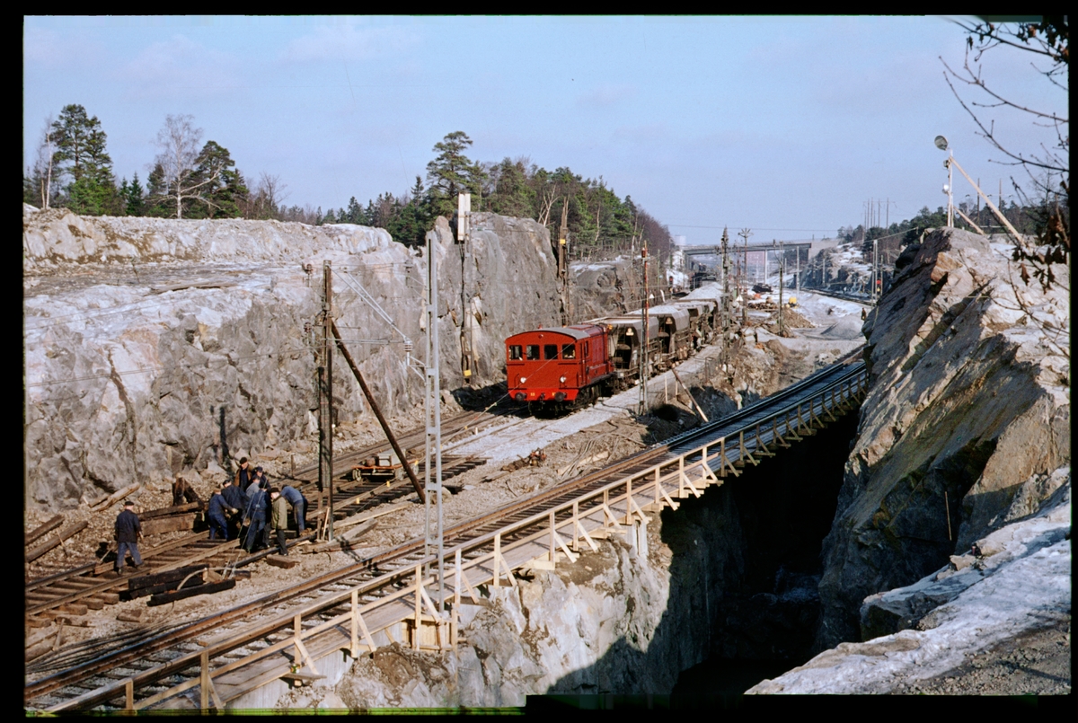 Foto taget från bron på Götalandsvägen i Älvsjö i riktning mot Stockholm centralstation. På spåret Statens Järnvägar, SJ V3 53 med godsvagnar.