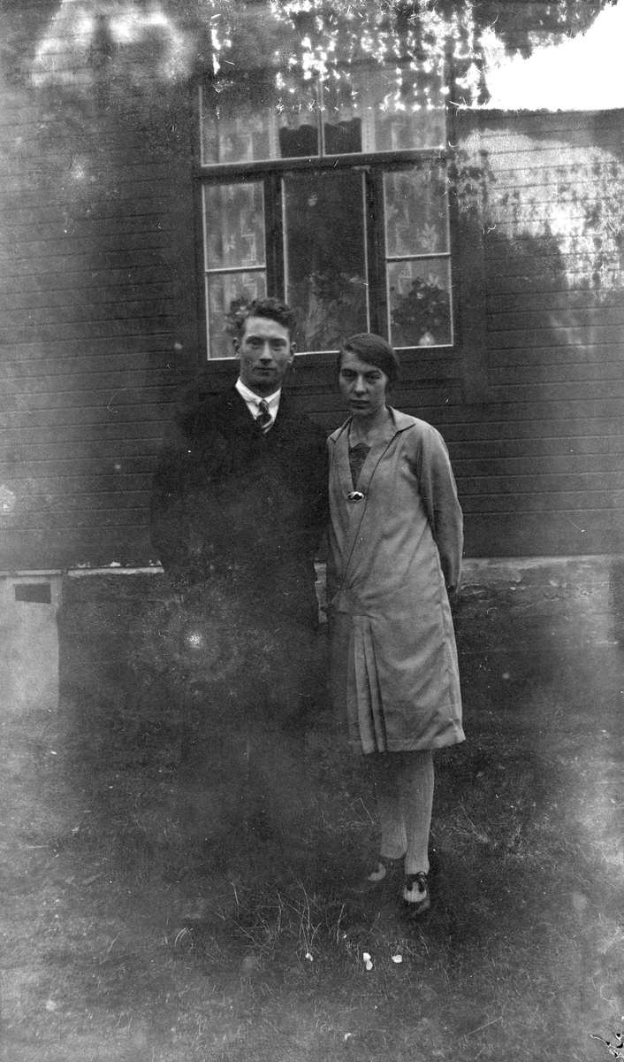 Portrett av par stående på gårdstun.