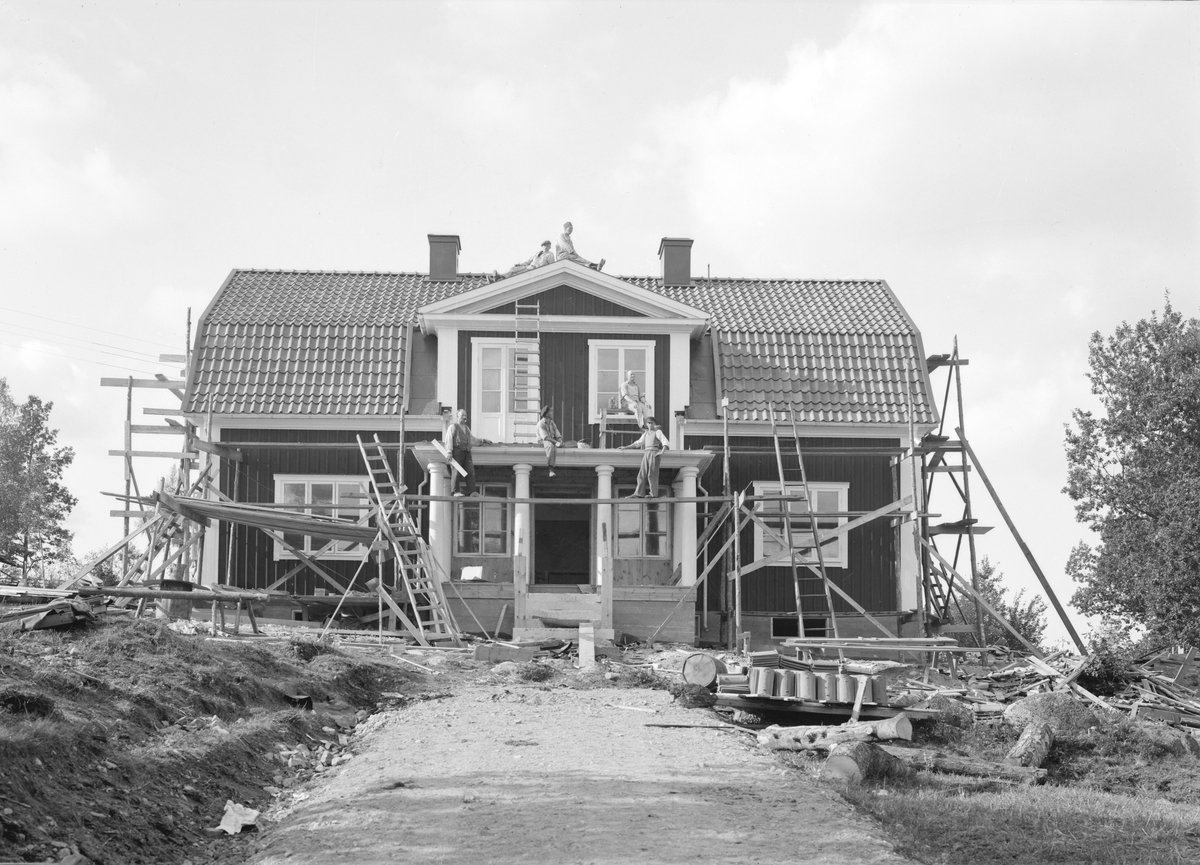 Ett nytt komministerbostället i Svinhult socken stod klart 1934. Här lägger ortens hantverkare sina sista händer vid bygget.