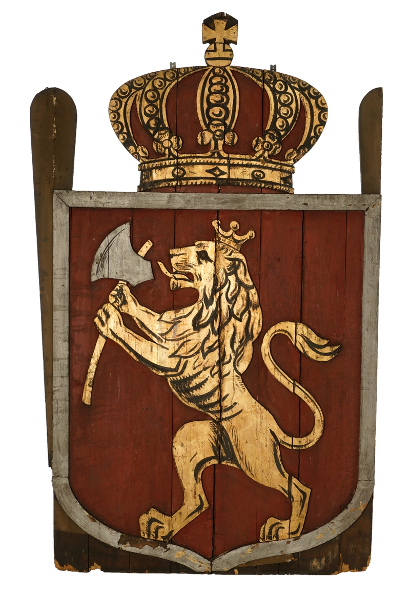 Bemalt treskilt, Riksvåpenet av 10.juli 1844. Kronen utskåret,løven påsatt skjoldet med sølvramme langs kanten.