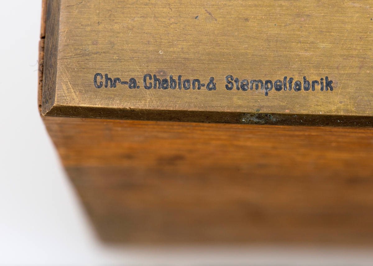 Kubikkberegningsapparat, levert av produsenten F. A. Krog i Skovveien i Kristiania, antakelig tidlig på 1900-tallet.  Apparatet er formet som et rektangulært skrin, utført i eiketre, men med "lokk" av ei messingplate.  Langs midtaksen på dette lokket er det ei lang, smal, rektanuglær spalte med glass under.  Gjennom denne ser vi ned på en tabell.  Tabellen er trykket på en papirrull, som er forankret på to valser nede i skrinet.  Tabellen kan beveges ved hjelp av dreiehjul på skrinets endeflater, to på hver side, ett i hver ende av de nevnte valsene.  Lengst til høyre i tabellvinduet finner vi "klassifiseringsinformasjon" - angivelser av stokklengder, diametere og salgsklasser.  Langs den øvrige delen av vinduet kan man lese av kubikkmeterangivelser for fra 1 til 70 stokker med samme dimensjoner og klassespesifikasjon.  Avlesinga skjer fra en tolinjet tabell på den nevnte papirrullen inne i skrinet, og med stokketallesangivelser på lokket - 1-35 stokker på oversida av vinduet og 36-70 stokker på undersida.  Det nevnte emaljerte lokket, som er hvitt med svarte tall og bokstaver, er skrudd fast til toppen av skrinet.  Det er grunn til å tro at valsene med tabellen må være montert før dette ble påsatt.  Skrinet er ellers lagd av høvlet eiketre, og den holdes sammen av de nevnte skruene i lokket og spiker fra botnstykket.  På standflata er det også hengslet en klaff, som kan vippes opp, slik at lokket skrår mot brukeren når apparatet brukes på et bord eller et annet plant underlag. 