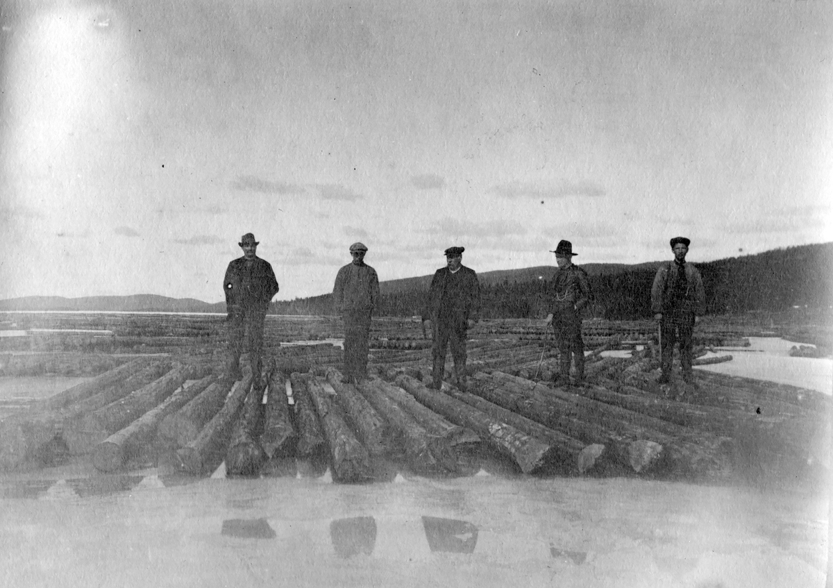 Tømmerfløting,Skasen 1913.
Fem menn står på tømmere.Tømmermerking.
