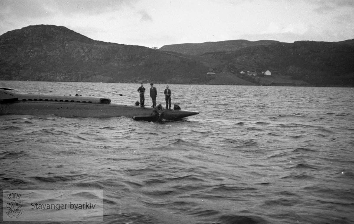 I dårlig vær på norskekysten ble dybderorene akter på den nye britiske u-båten HMS "Triad" skadet. Destroyerne HMS "Inglefield" - D02 - og HMS "Maori" - F24 - gikk til assistanse og eskorterte "Triad" inn i Mastrafjorden 30.11.1939.. .Offiserer på den norske torpedobåten "Stegg" bordet "Inglefield" for konferanse. "Triad" ble først forsøkt reparert i Mastrafjorden, men da dette ikke lyktes måtte u-båten taues til Rosenberg mek. verksted for reparasjon. De to destroyerne forlot da norsk farvann.. .Alle de fire ovenfor nenvte skipene i foto-serien gikk tapt i løpet av krigen...Heist kommando:."Stegg" 1921-1940."Triad" 1939 -1940."Inglefield" 1937 - 1944."Maori" 1938 - 1942..(Opplysninger gitt av Einar Haualand, 30.10.2022)...