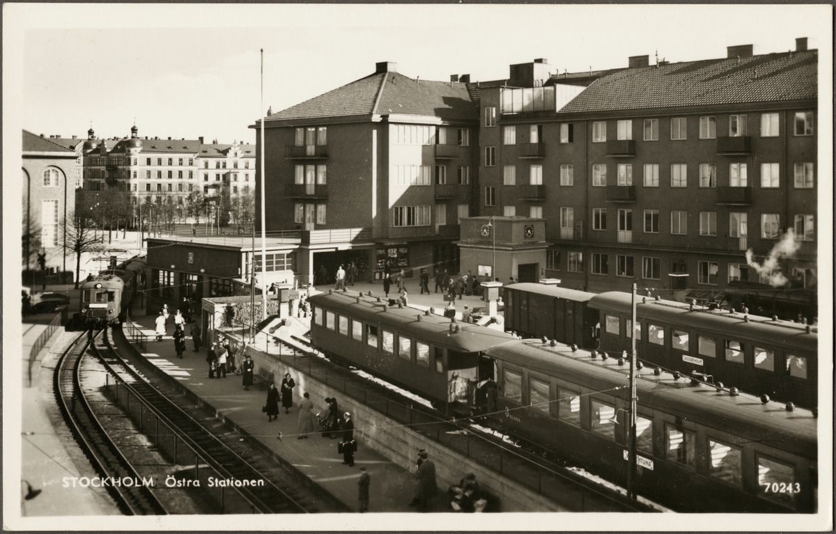 Vy på Östra station med resande och vagnar.