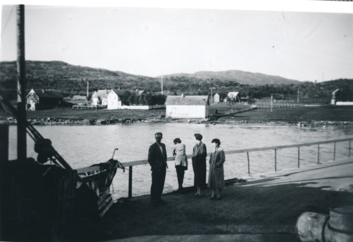 Fire personer venter på "Dampen" på Eidetkaia. Sellevoll i bakgrunnen.1957-58.