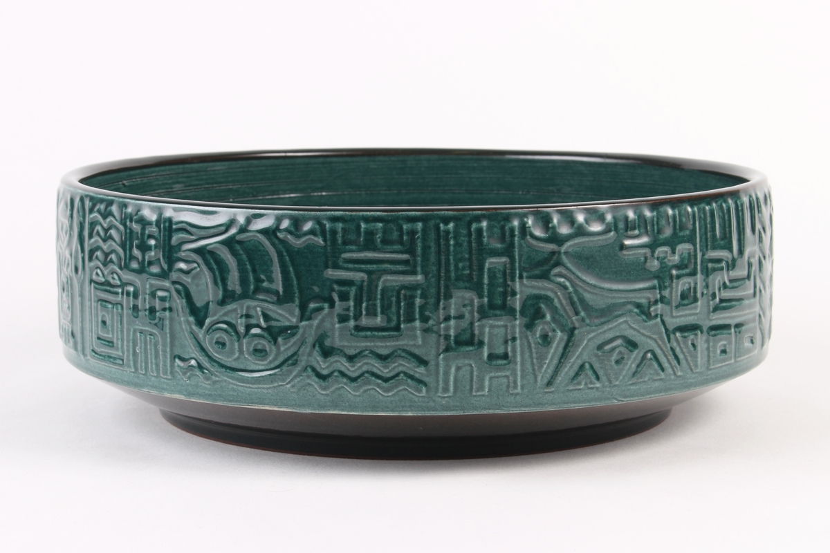 Skål som utvendig er dekorert med relieff som viser vikingmotiv. Innvendig med spiralformet dekor.