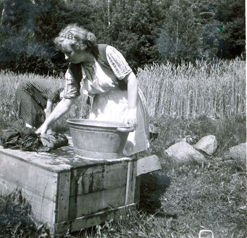 Karin Larsson (född 1902) tvättar kläder i en balja, Hallen 1:4 "Josefs" cirka 1950. Sommargäst från Såggatan i Göteborg som åren 1943 - 1963 hyrde Hallen 1:4 "Josefs".