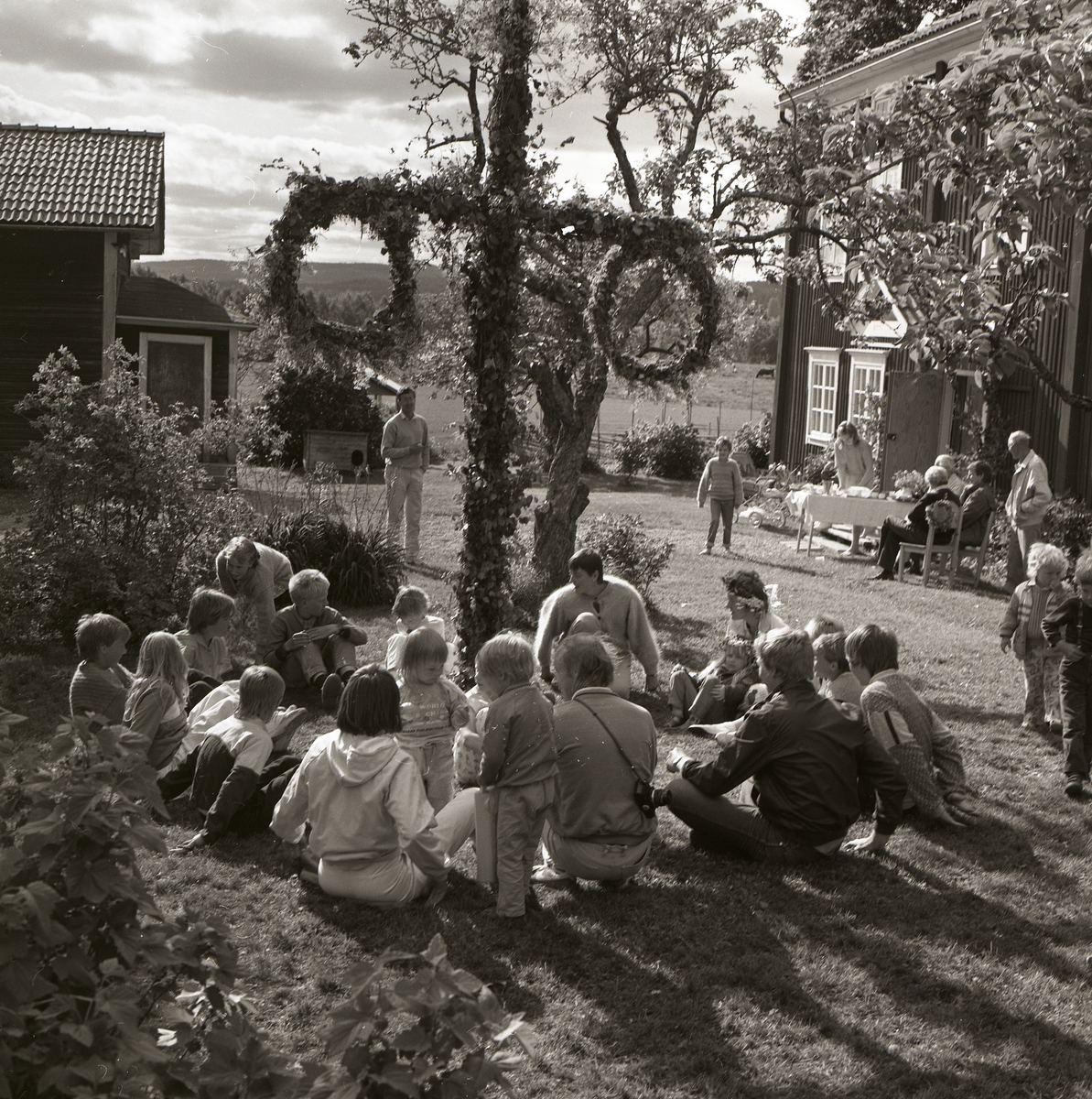 Midsommarfirare har samlats kring midsommarstången på Norrgården, 21 juni 1986.