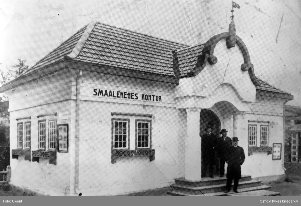 Smaalenenes kontor, antakelig på Jubileumsutstillingen i Frognerparken i Kristiania 1914. Mennene er ukjente.