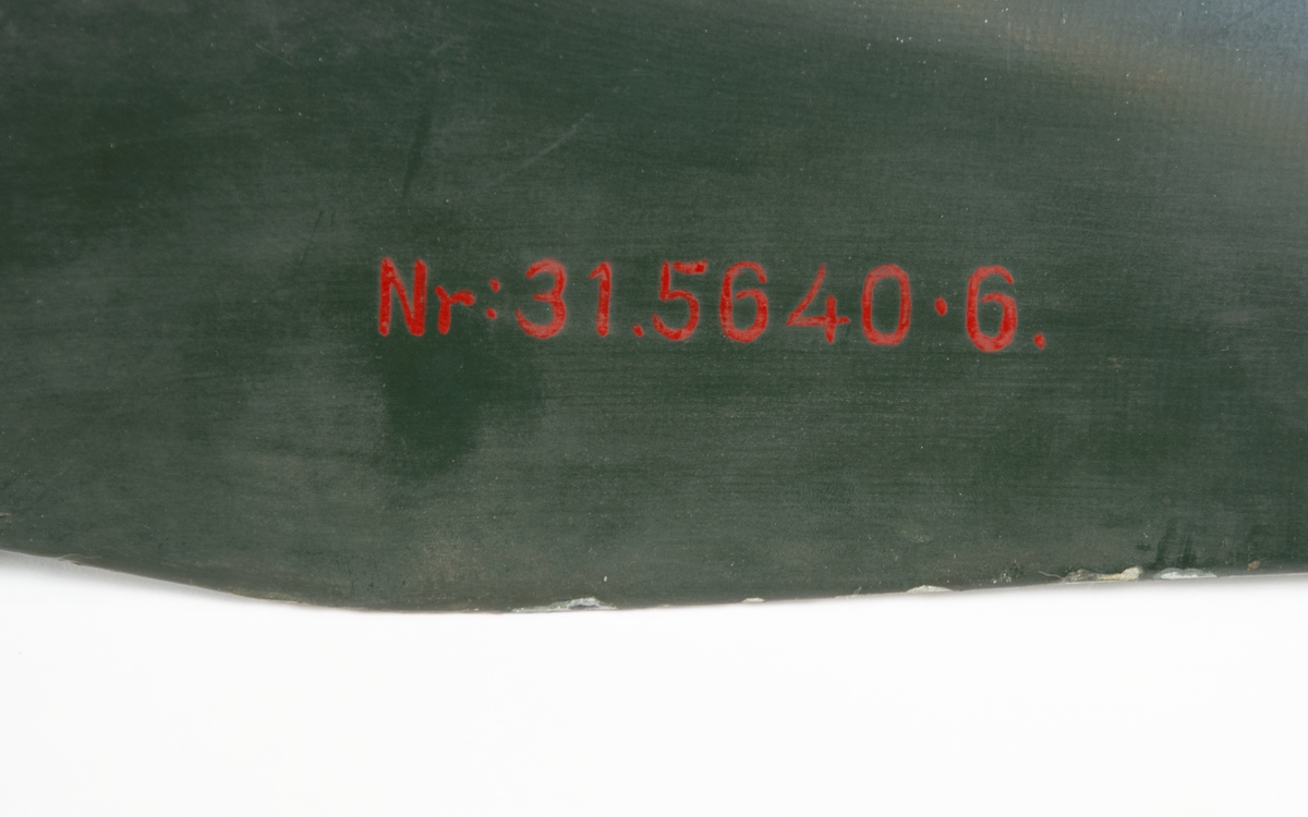 Grön tvåbladig propeller av märket Heine. På vardera vingblad är tillverkarens emblem målat, ett svart H med silvrig bakgrund.