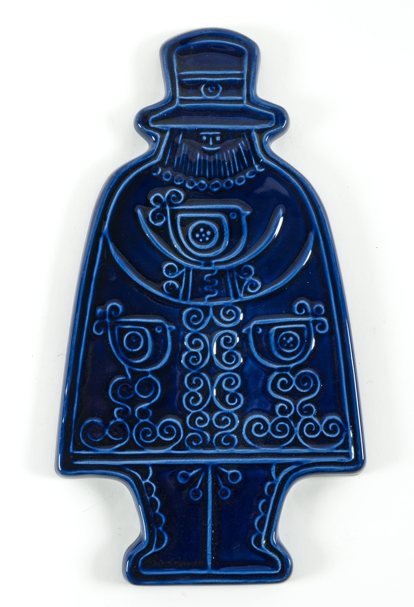 Relieffigur i blåglaserad flintgods från Steninge Lervarufabrik. Figuren föreställer en man med skägg och hatt. Fågelmotiv på hans dräkt. Troligen tänkt som väggdekoration. Troligen tillverkad under perioden 1960-1980 pga stilen. Bildar ett par tillsammans med relieffigur föreställande en kvinna, GM41873.