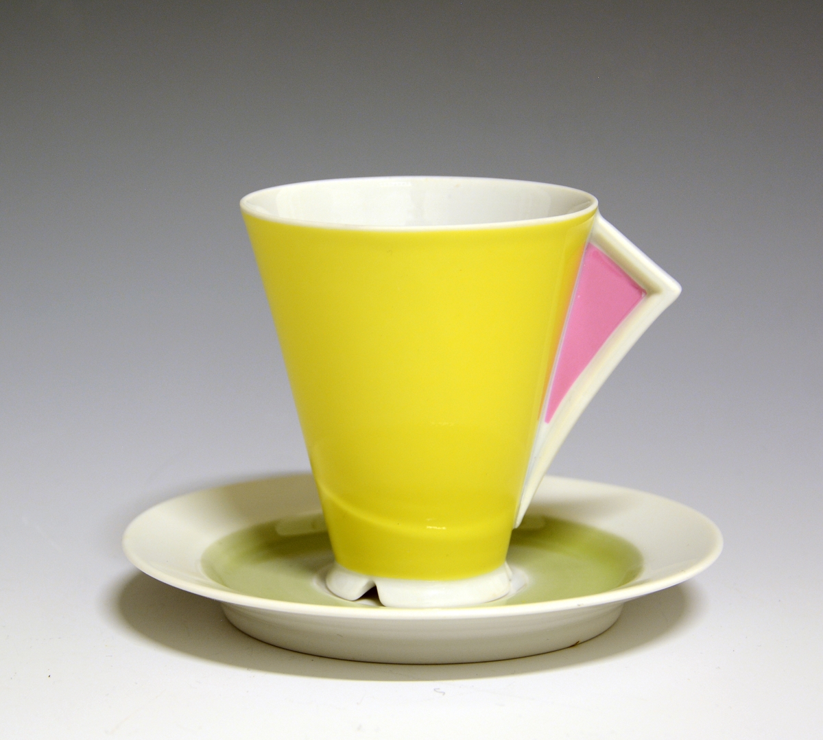 Kaffeskål av porselen, dekorert med et lysegrønt bånd innerst på fanen.
Modell: Style

Hører ikke til koppen TGM.2019:158.A.