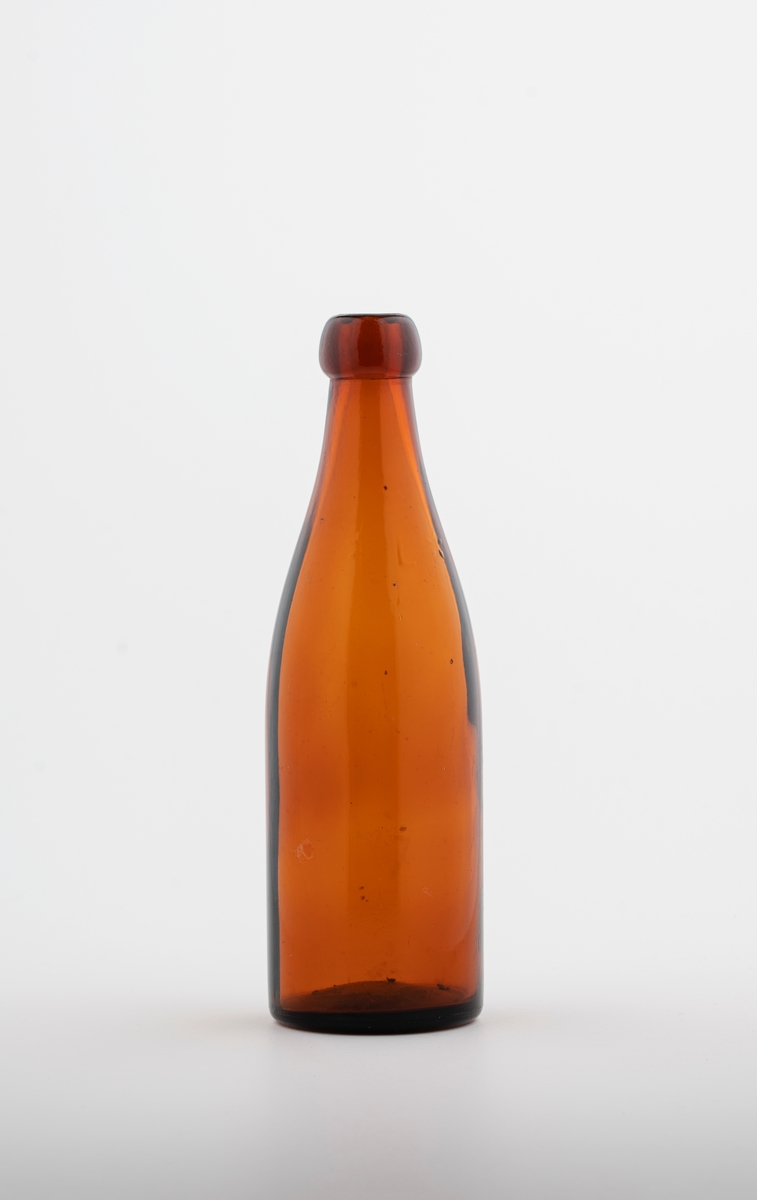 slank flaske i glass til omtrent 3-5 dl. Rund tut med ganske smal åpning.