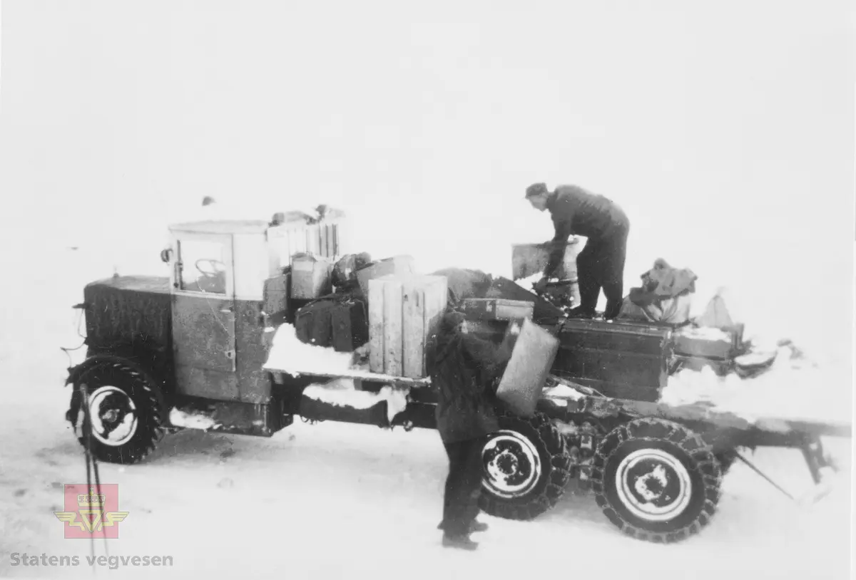 I 1928 ble det åpnet veg over Hardangervidda fra Eidfjord til Haugastøl. Strekningen Geilo-Haugastøl stod ferdig i 1938. Vegen over vidda var vinterstengt fram til 1940. Åpningen skjedde normalt ved St. Hans. Å åpne vegen etter vinteren var en omfattende oppgave, men varierte avhengig av snø- og værforhold.
Hardangervidda fikk den første boggi-brøytebil 1933. Bilen var av merket Strømmen og hadde en motor på 110 hk. Den ble første gang registrert som D 5061, omregistrert i 1941 til F 13622. Lastebilen var også i bruk under krigen. Her laster to mann opp utstyr og proviant, trolig for nytt mannskap som skal inn på vidda.