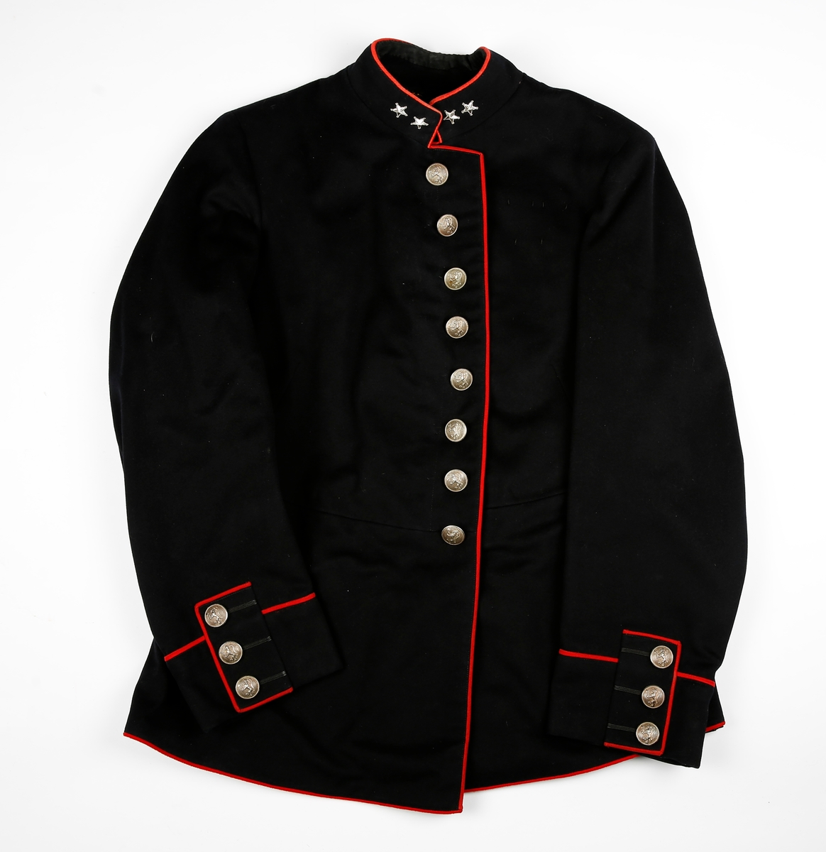 Mørk blå uniformsjakke med røde tittekanter. to stjerner på hver side av kragen. Fòret. 