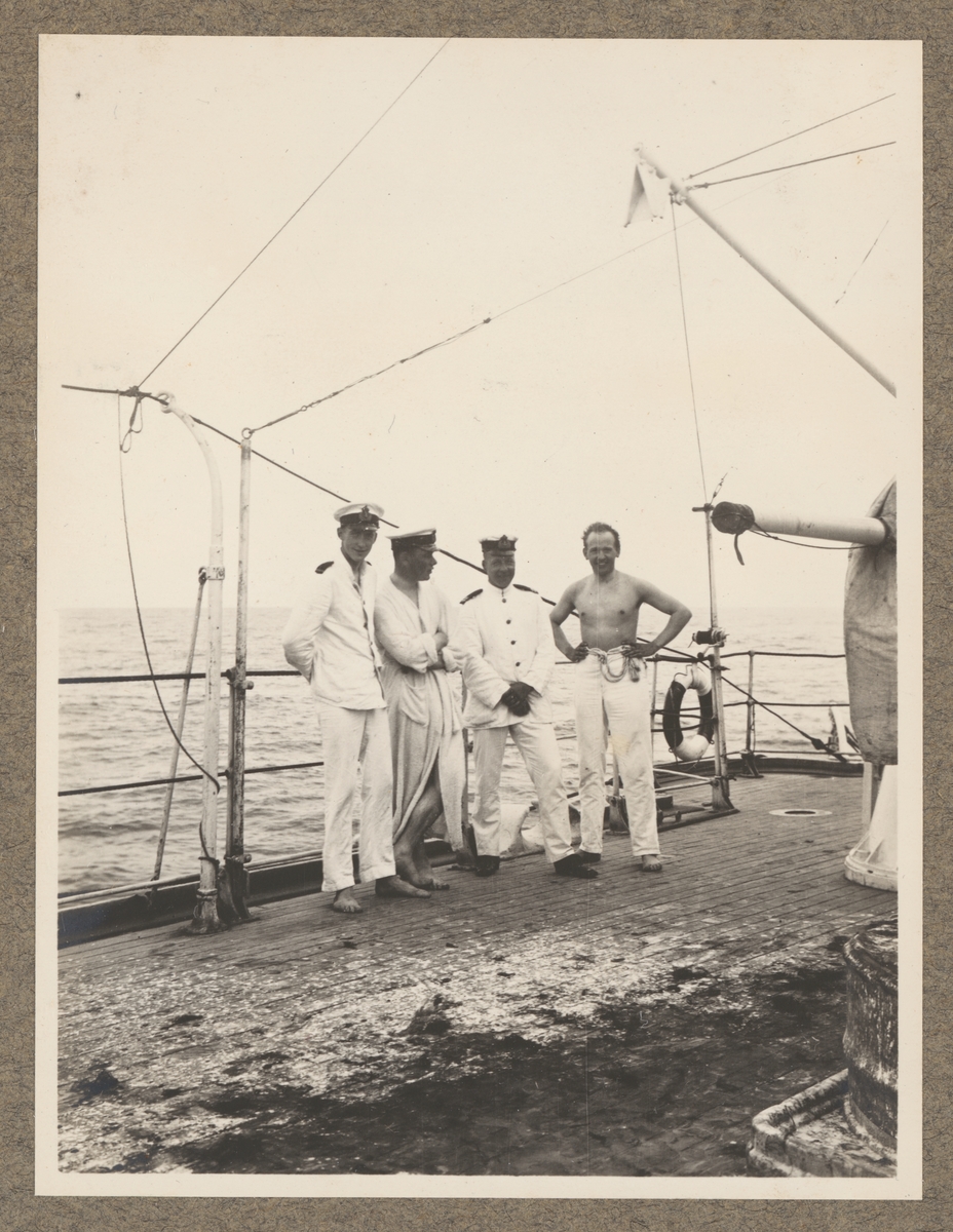 Bilden föreställer fyra sjömän efter linjedopet ombord på Fylgia. En är klädd i badmantel, en annan har bar överkropp, framför de syns resterna av rengöringen.