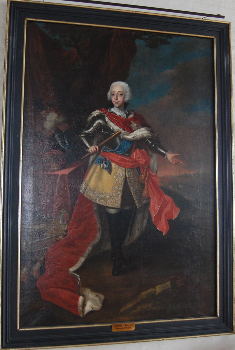 Portrett av Fredrik V av Danmark i helfigur, stående, ikledd en gul tunika under en brystplate, med en rød kappe med hermelinpels.