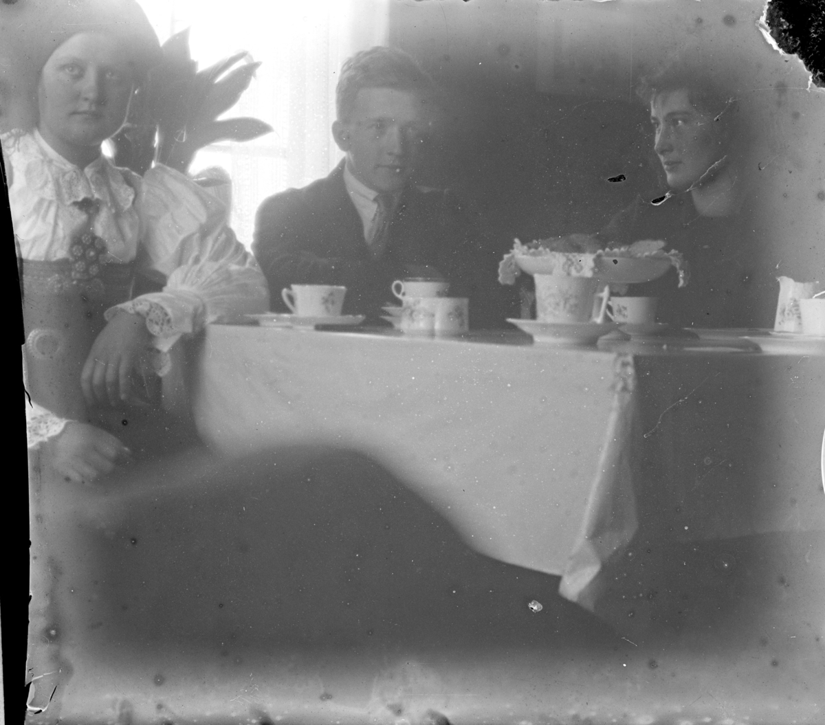 Kaffeslabras, tre personer med ei i setesdalsbunad. Trolig Voss Folkehøgskule.