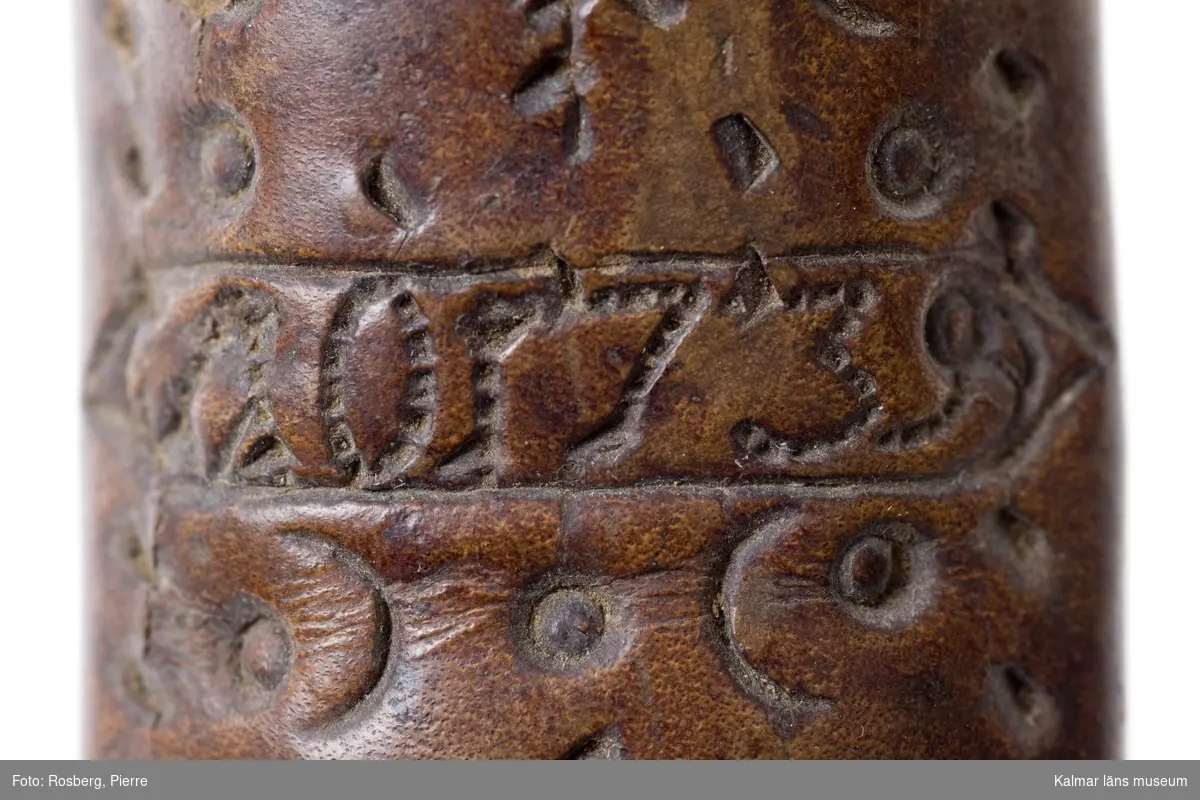 KLM 2915. Knivslida av läder. Läder med pressade ornament, däribland rosetter och hjärtan. Mitt på: AO 1739. Svagt böjd. Två fack, eventuellt använd för bestick.