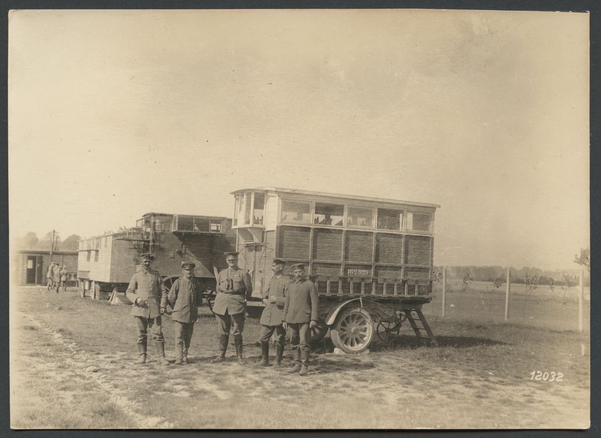 Bilden visar en grupp soldater som poserar framför vagnar med brevduvor.