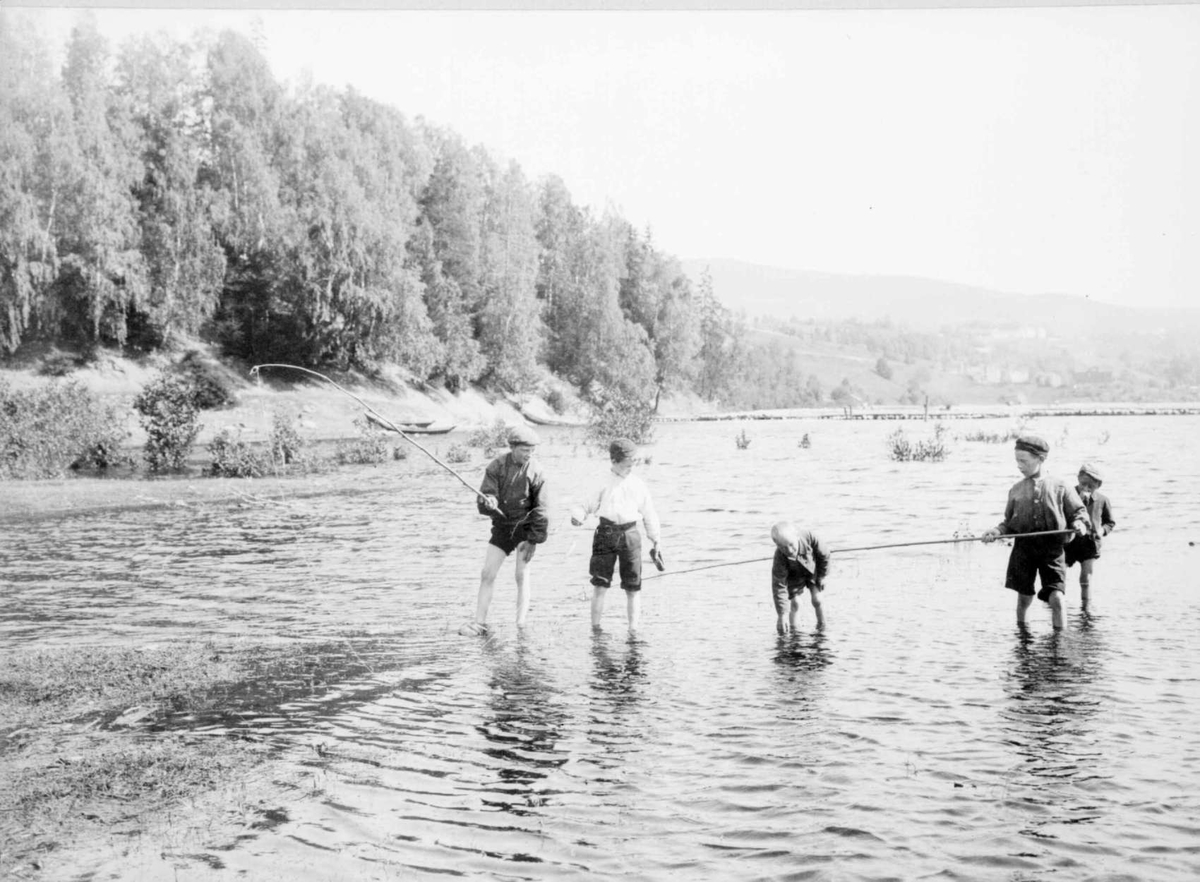 Repro: Fem gutter som vasser og fisker i vann.