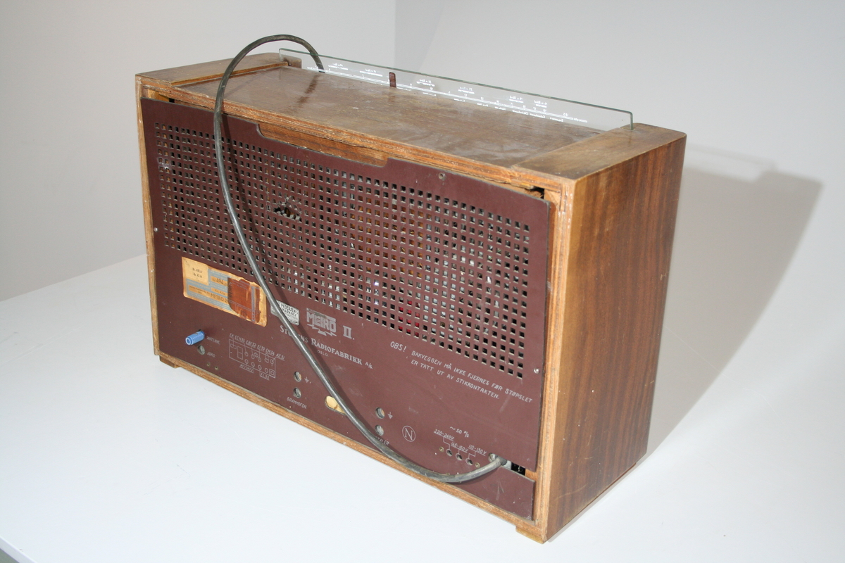 En rektangulær radio med inngang  for grammofon, 220-240V, 145-160V, 110-130V og  utgang for eksterne høytallere, antenne, jord. Det er innebygd høytaler. Det er satt inn et grønnt stoff over det orginale stoffet over høytaleren