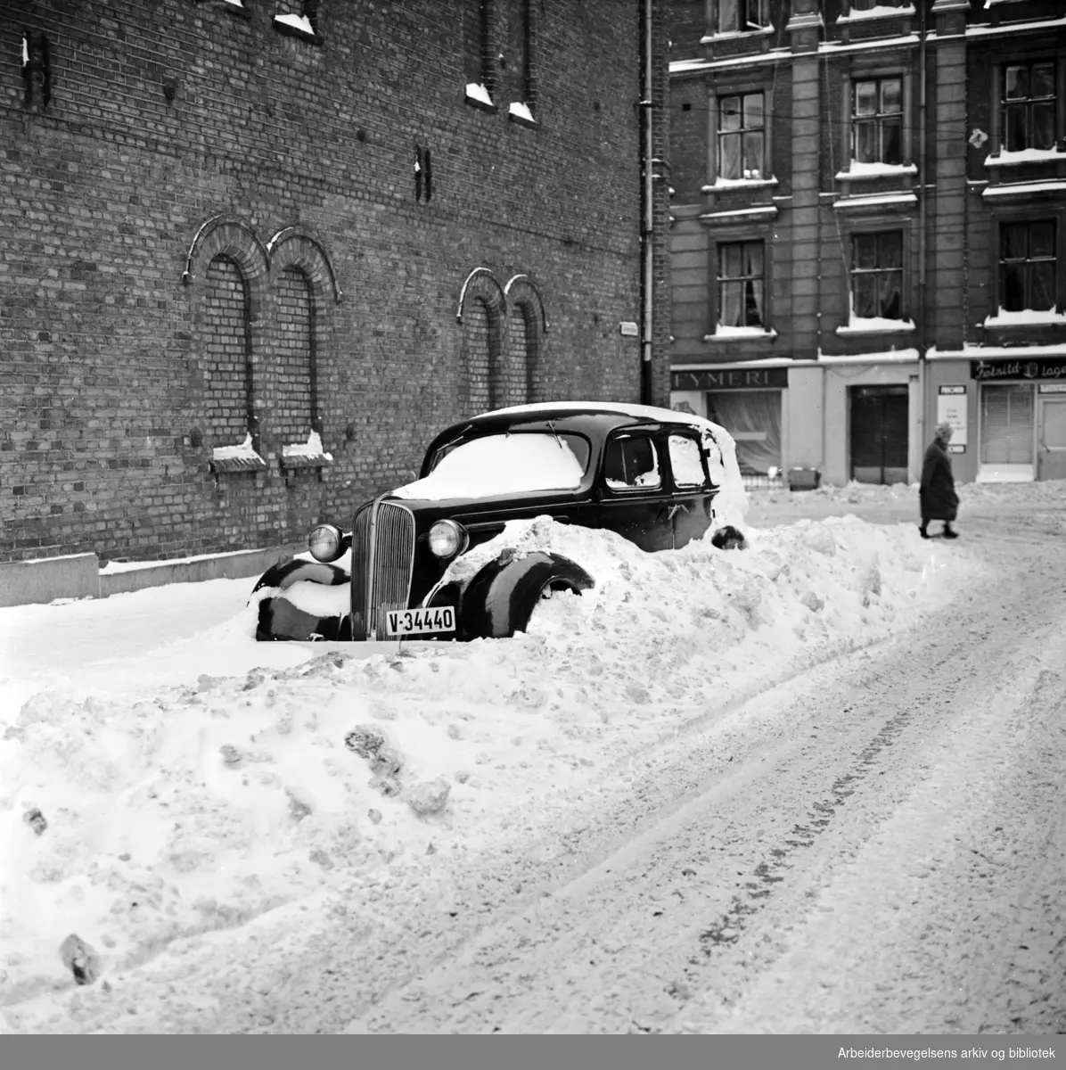 Parkert bil i snøfonn. Dalsbergstien, sett mot Pilestredet. Desember 1962.