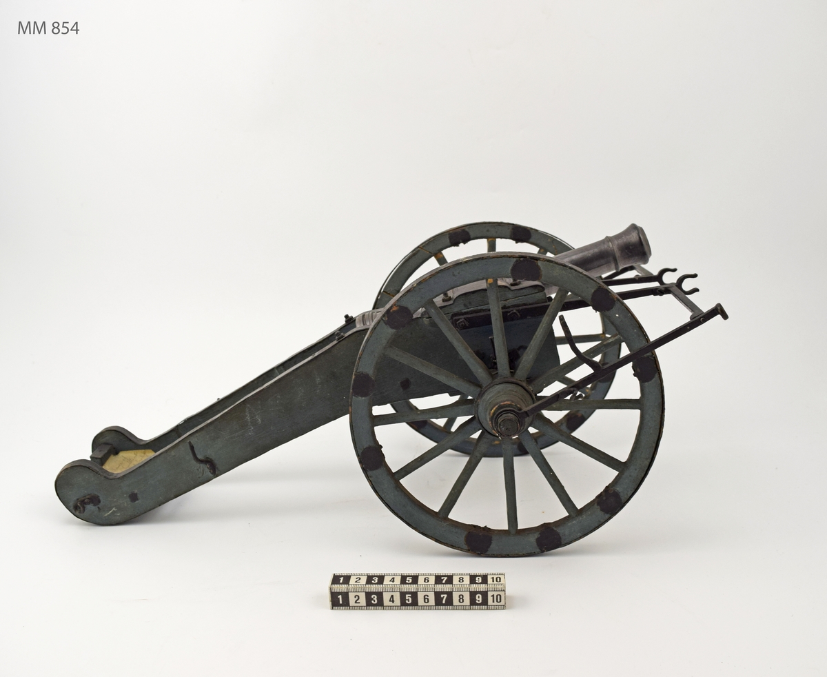 Kanonmodell: Modell av Artillerifältkanon med landlavett och 2 hjul. Modellen av trä, med beslagen av järn. Lavetten L = 460 mm B = 330 mm H = 190 mm.