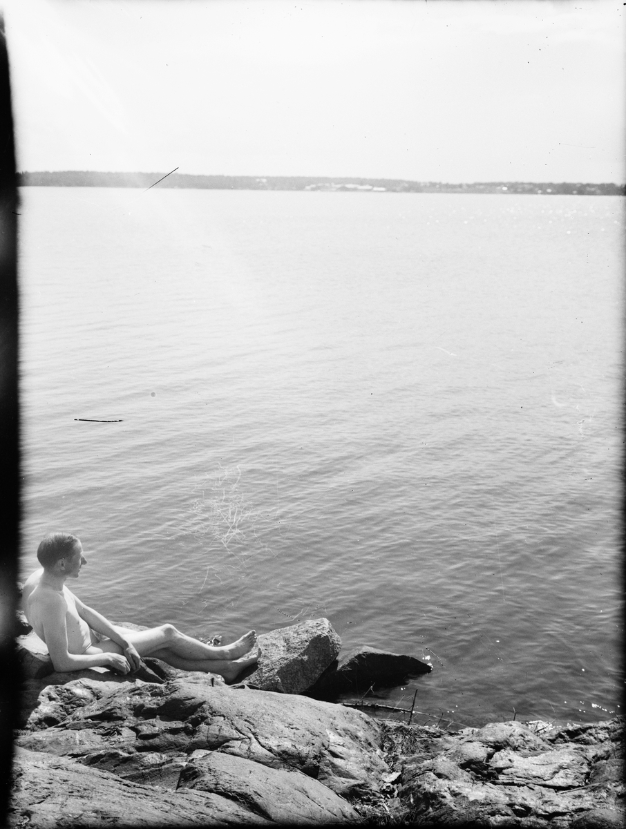 Skärgårdsvy - man sitter naken på klipporna, Östhammar, Uppland