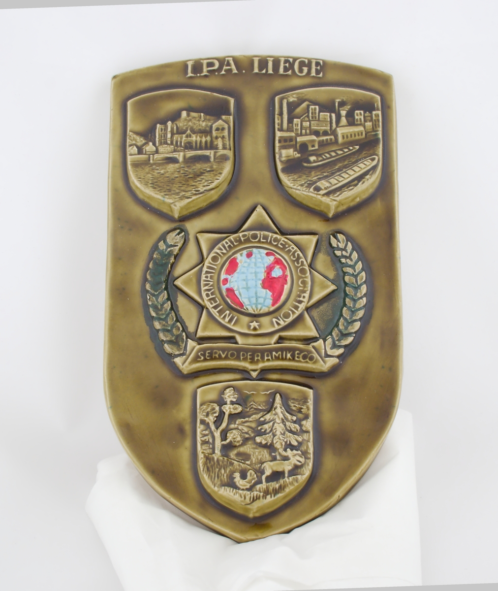 Brunt/hvit porselens emblem med tre bilder og IPAs logo.