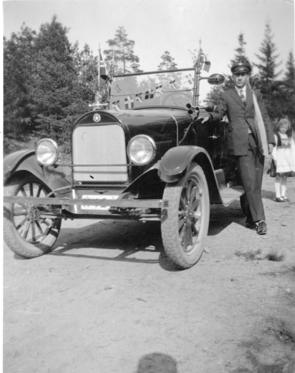 Johannes Stahlsberg Eriksen, står ved sin pyntet bil 17.mai 1926. Pike pyntet i Hardanger bunad .