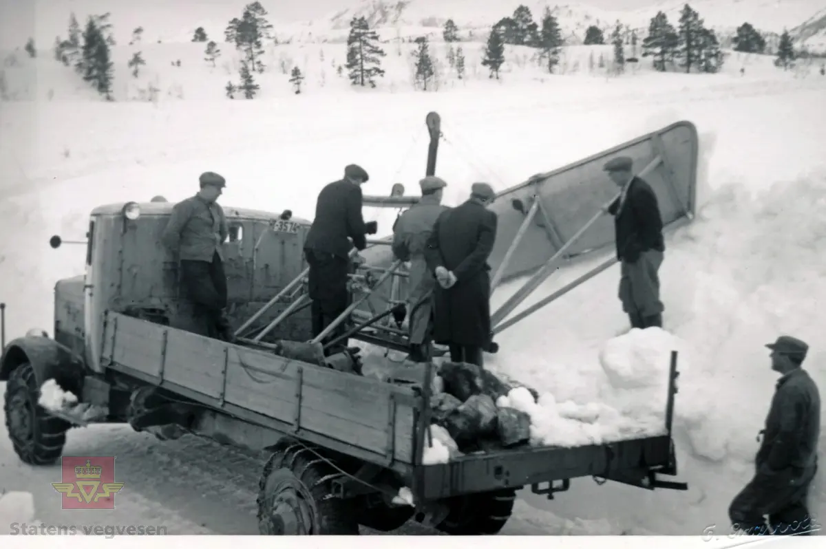 Utvikling og utprøving for vegvesenet av en kantplog - "rømmeving" - i 1948 på Riksveg 65, Nordmarka i Surnadal. 
Büssing-NAG med registreringsnummer T-3574. Merkehistorien til Büssing, Büssing-NAG, MAN-Büssing og N.A.G., i Asbjørn Rolseth's "Norsk lastebilleksikon bind II, Lastebiler i Norge 1940-1990", side 45-52. 

Demonstrasjon og utprøving av "rømmeving". Fra venstre: Nils Røyme, Ola Bæverfjord, vegsentralsjef Ernst Aas, avdelingsingeniør Sverre Hollum, oppsynsmann Ola Husby og sjåfør Lars H. Røv. (Kilde: Informasjon bak på foto).