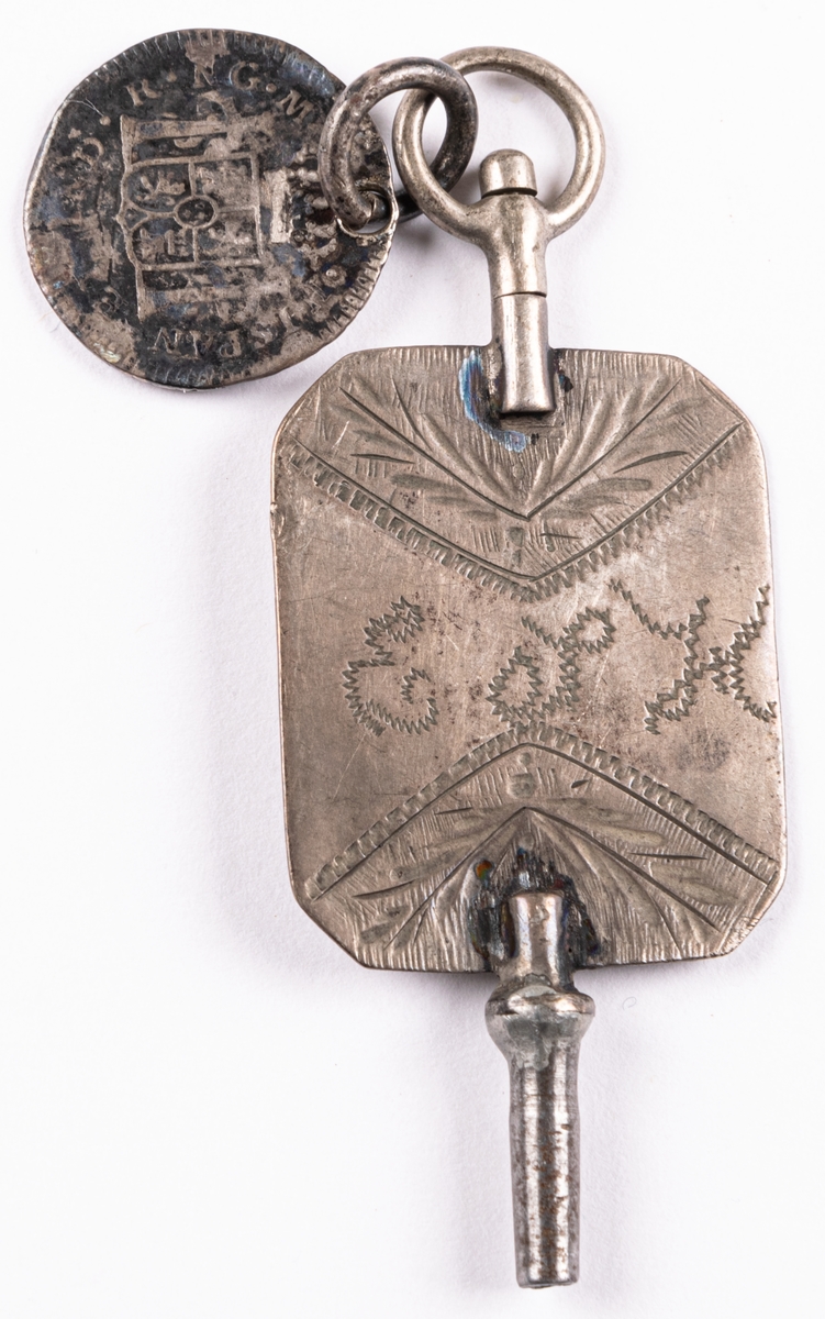 Urnyckel av silver, med vidhängande spanskt-colombianskt mynt (8 reales) från 1809, (Ferdinand Dei Gratia) också i silver. Nyckeln märkt E.S.H.