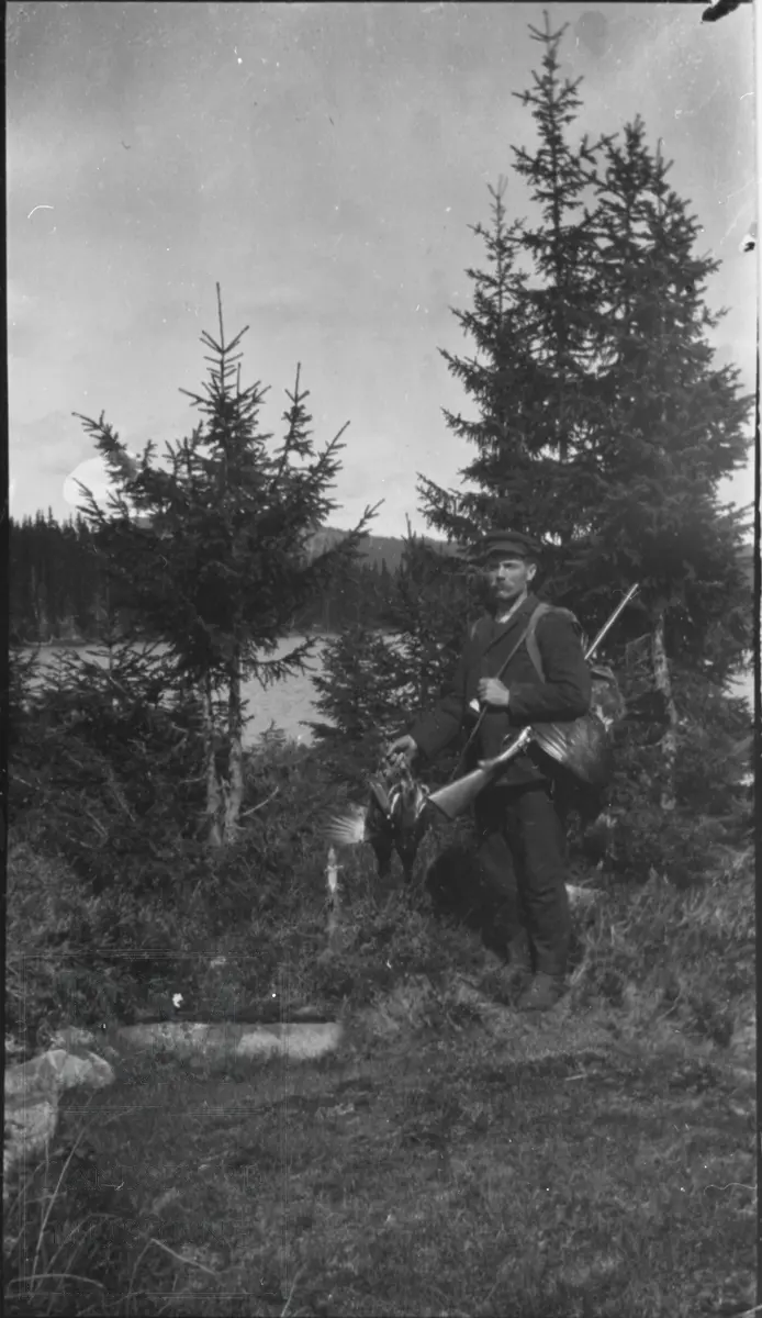Emil Nielsen i skogen ved Vassbråa med børse på skuldra og med flere skutte storfugl