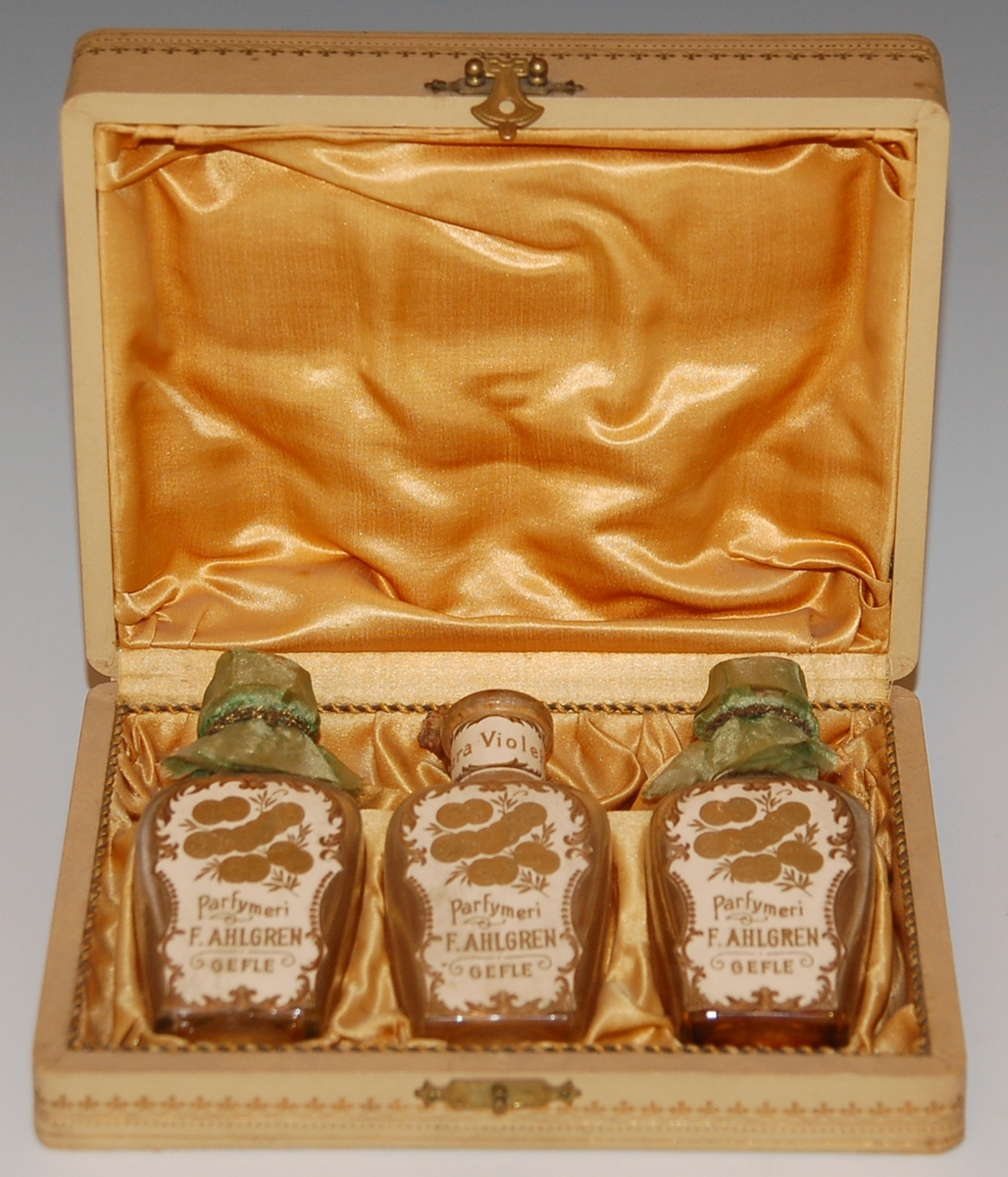 Etui med tre parfymflaskor.
På locket text i guld:
"Parfymeriet 
F. Ahlgren
Gefle"