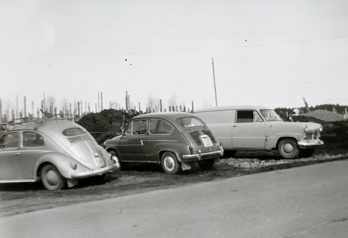 Kvello, Stange. Selvbygging, husbygging, dugnad, parkerte biler. 
Fra venstre: Folkevogn (oval bakrute tilsier årsmodell 1953-57), NSU Jagst (kromstripen langs siden viser at det er den tyskproduserte versjonen av Fiat 600), Ford Taunus 12M varebil 1953-ca. 1960.