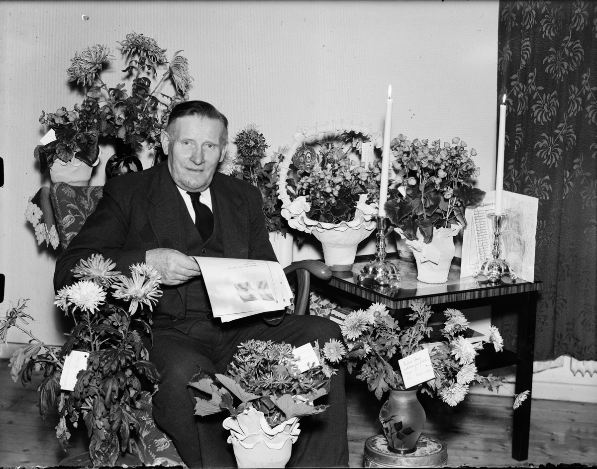 Oscar Claesson omgiven av blommor firar 60-årsdag, Östhammar, Uppland 1950
