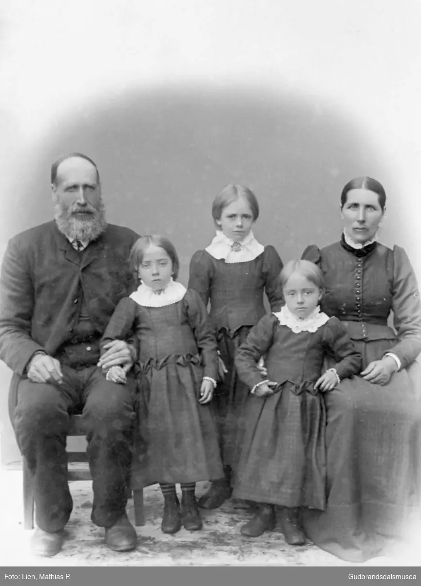 Portrettbilde av familien Brendjord, fem personer, mann og kvinne med tre barn. Familien står på Nordpågarden, Bjølverud (6-6).
