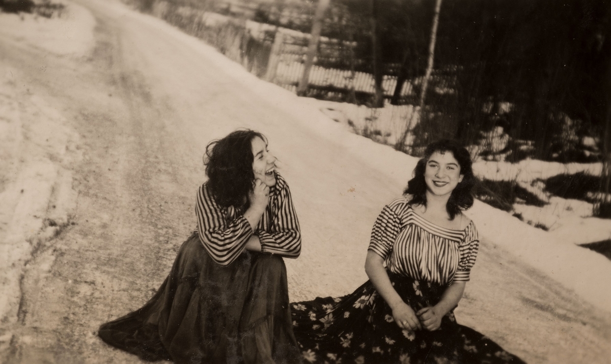 Två romska systrar sitter på en plogad vinterväg, januari 1947 i Storvik.