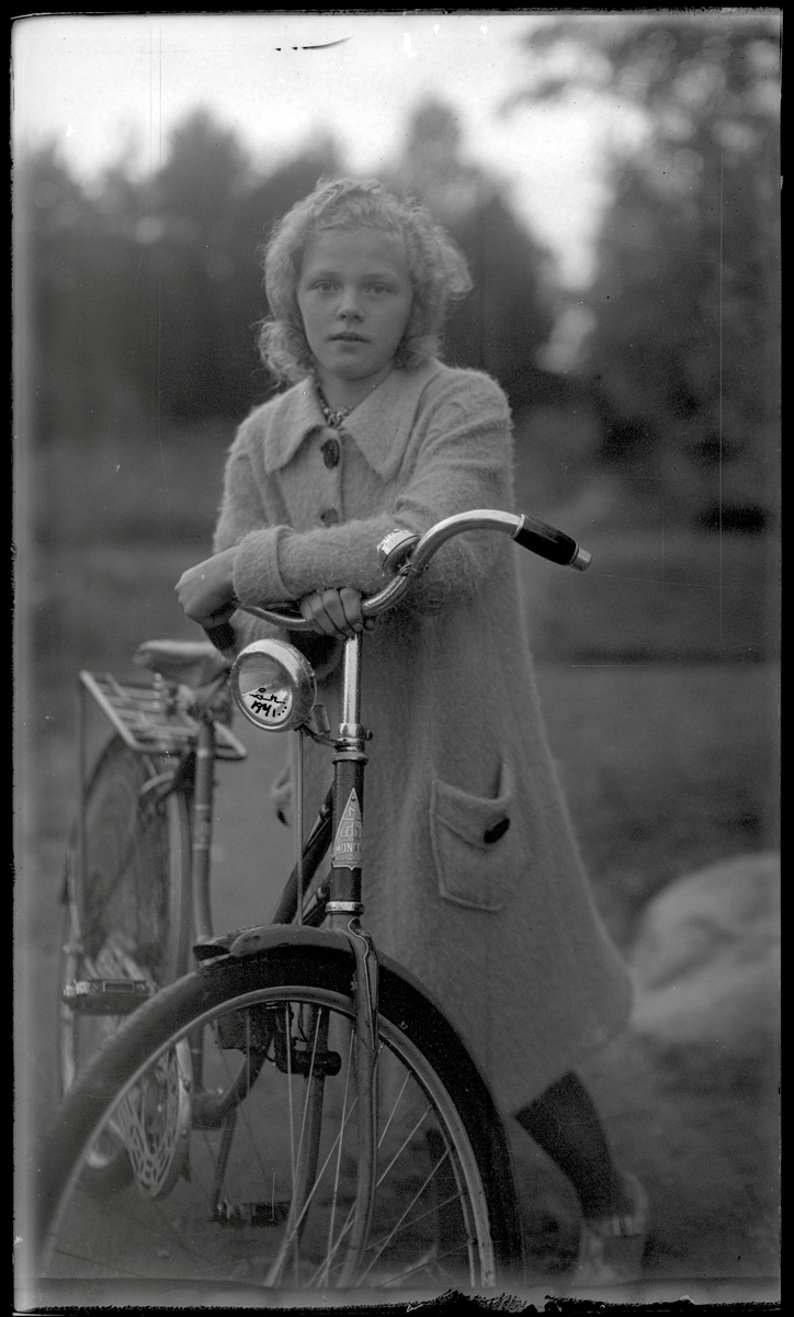 Ung kvinna med cykel