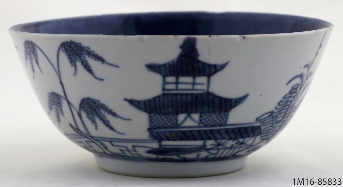 Spillkum eller skål av vitt ostindiskt porslin. Dekorerad med pagodlandskap i blått.