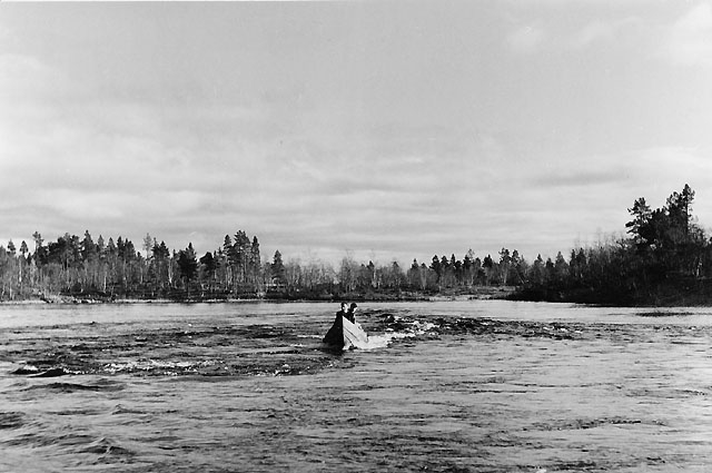 Sarri styr båten skickligt och säkert uppför Paitajärvis forsar.