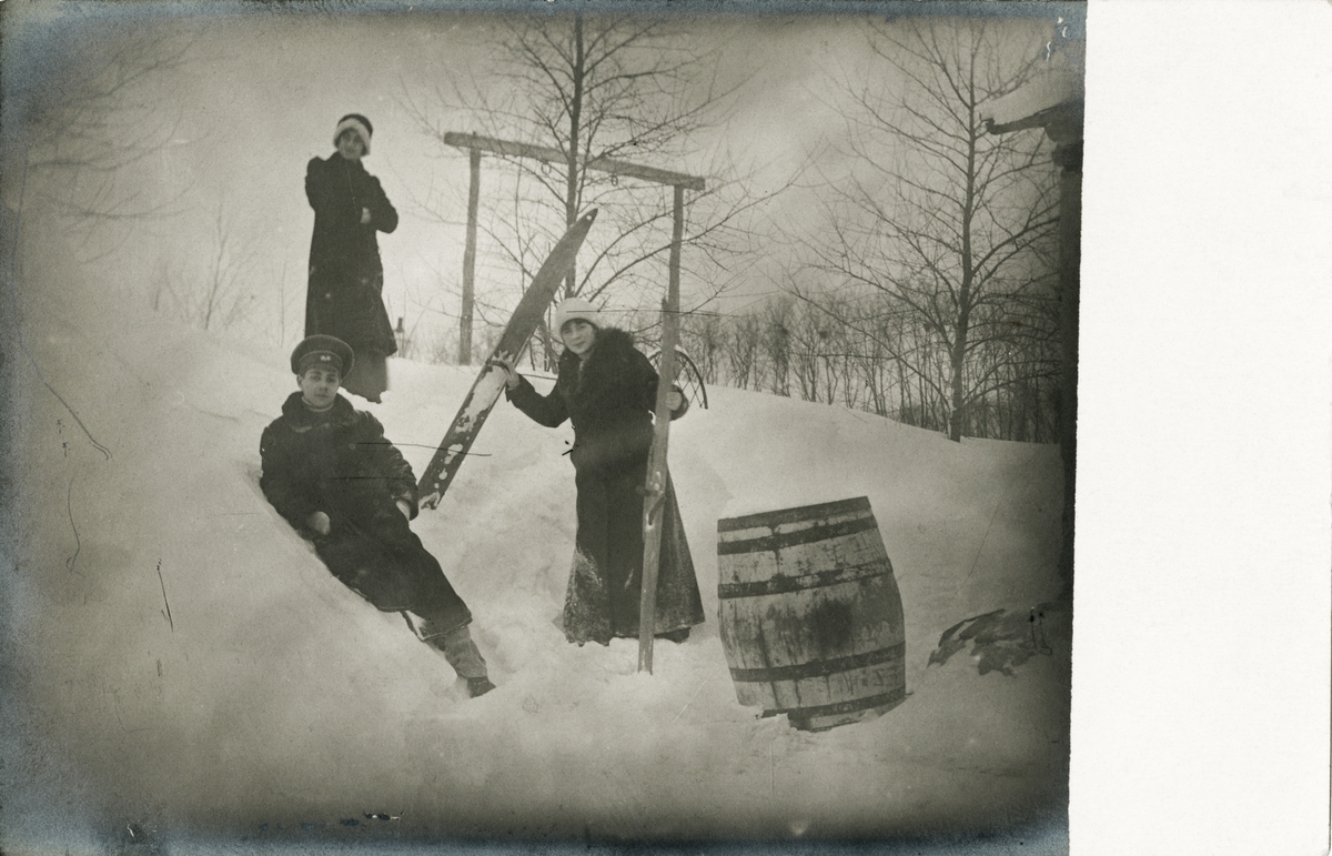 Serafima (øverst), Nikolaj (liggende i snøen) og Victoria (til høyre) leker i snøen med et par ski.