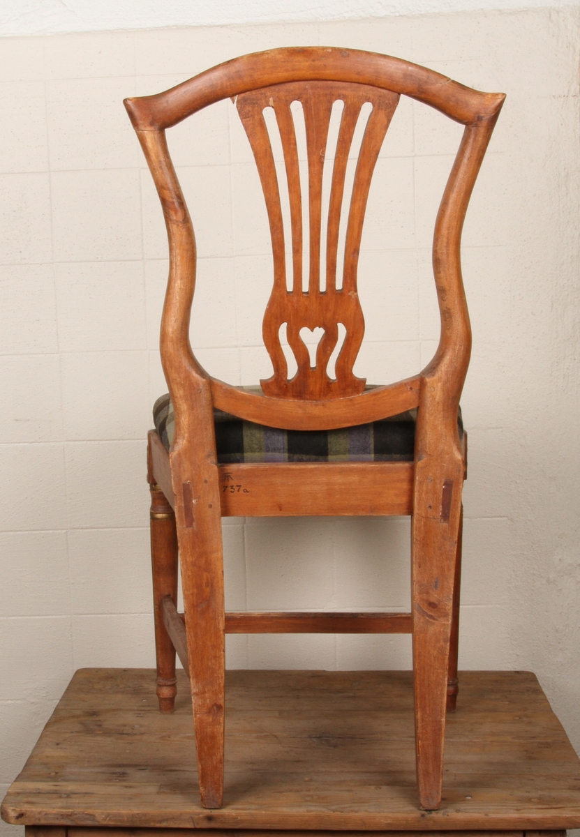 Stolen har lyreformet rygg. Frambeina er dreide og riflete, og øverst på ryggen er det bladornamentikk.