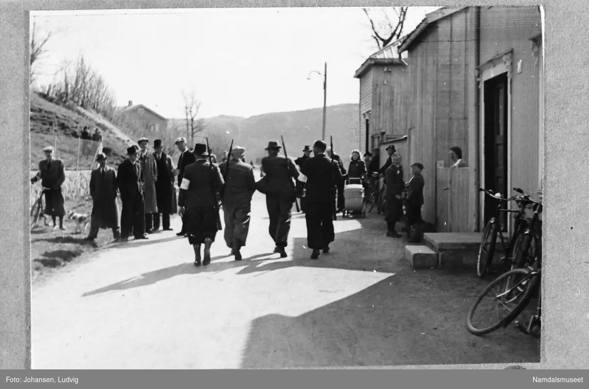 Skolegata, Namsos, 8. mai 1945. 4 nye politifolk patruljerer med geværet på aksla.