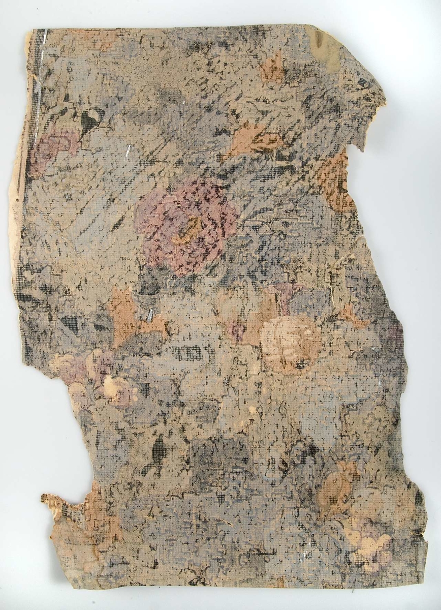Ett fragment av blommig tapet med mönster i blått, lila och orange. Har suttit under tapet UM42230.