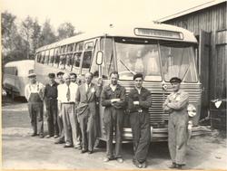 Personale ved NSB Hølandsrutene foran turistbuss utenfor ver