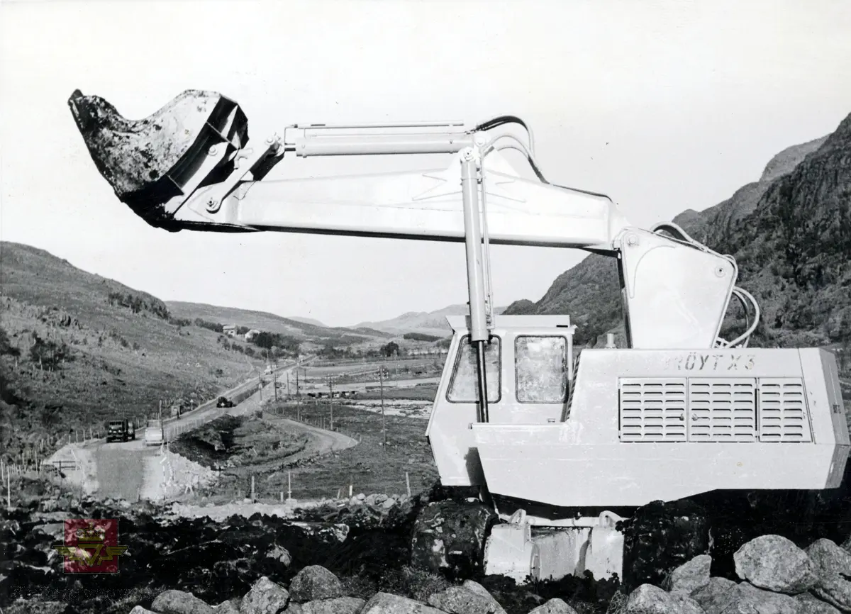 Brøyt X3, 1965 modell i arbeid på Europaveg 18-anlegget på Kyllingstad i Gjesdal kommune. 
Skilt på gravemaskinen: "Brød. Søyland Bryne Norway."
Bilde 2) Viser landskapet og gravemaskinen sett fra siden.