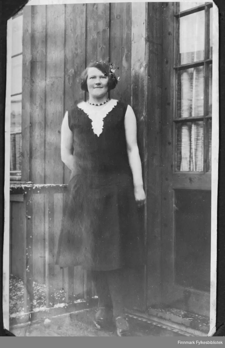 Sofie Andreassen (gift Lindbäck) står på trappa utenfor et hus i Børselv før krigen.