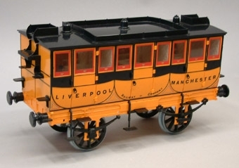 Modell av engelsk personvagn i skala 1:16. Vagnen är orange med svart tak och svarta detaljer.
Samhör med modellen av loket Rocket Jvm10204-1